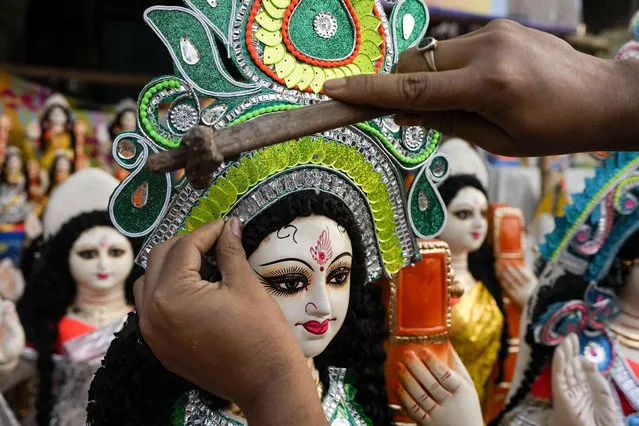 An artisan gives finishing touch to an idol of Saraswati, the Hindu goddess of learning, at a roadside stall ahead of its worship scheduled for Saturday, in Kolkata, India, Thursday, February 3, 2022. (Photo by Bikas Das/AP Photo)