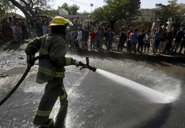 A fire fighter sprays water to clean the site of a suicide car bomb attack in Kabul, Afghanistan, June 30, 2015. (Photo by Omar Sobhani/Reuters)