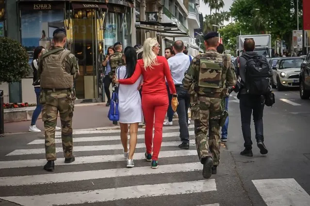 Military officers and festivalgoers walk along the Croisette Boulevard near the Festival Palace during the 69th Cannes Film Festival, in Cannes, France, 11 May 2016. The festival runs from 11 to 22 May. (Photo by Carsten Riedel/EPA)