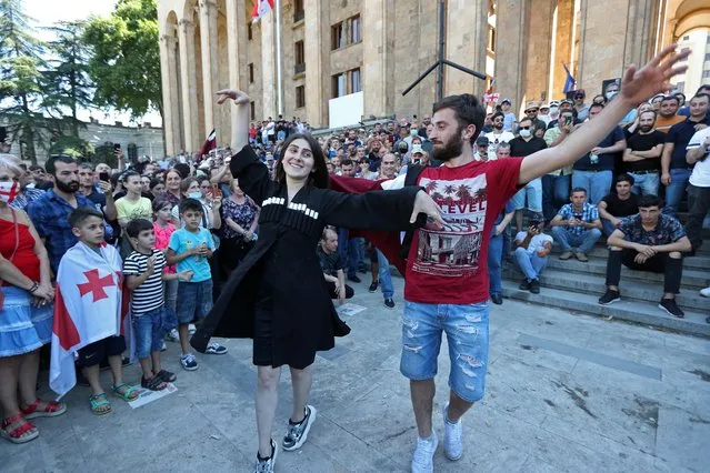 People dance in front of the parliament building as they celebrate after LGBT+ campaigners called off plans to stage the March for Dignity during Pride Week in Tbilisi, Georgia on July 5, 2021. (Photo by Irakli Gedenidze/Reuters)