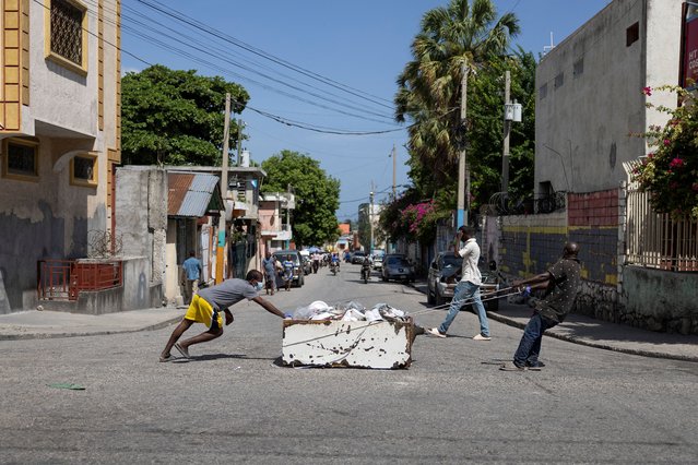 Men move a dead body inside an old refrigerator, following the arrival of the first contingent of Kenyan police as part of a peacekeeping mission in the Caribbean country, in Port-au-Prince, Haiti on June 30, 2024. (Photo by Ricardo Arduengo/Reuters)