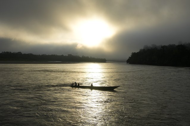 People traverse the Mantaro River at sunrise in Santa Maria de Nieva, Peru, Wednesday, June 26, 2024. (Photo by Martin Mejia/AP Photo)