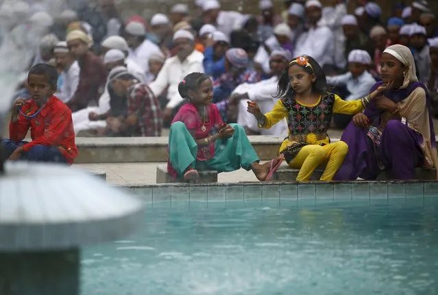 Children play near a fountain as Nepali Muslims attend a mass prayer during Eid al-Fitr celebrations at a mosque in Kathmandu July 18, 2015. The Eid al-Fitr festival marks the end of the Islamic holy fasting month of Ramadan. (Photo by Navesh Chitrakar/Reuters)