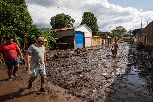 People walk in mud caused by floods that swept through the town after Hurricane Beryl passed off the Venezuelan coast, in Cumanacoa, Venezuela on July 2, 2024. (Photo by Samir Aponte/Reuters)