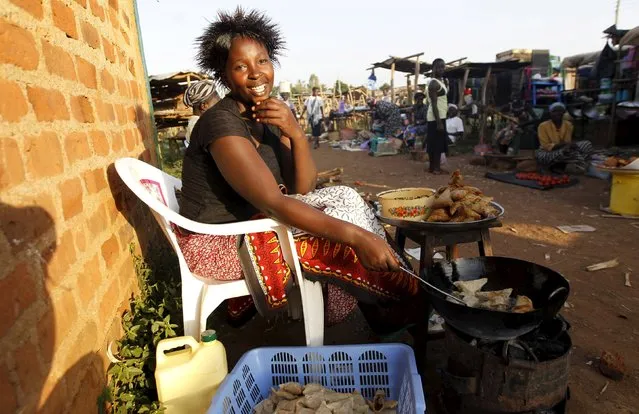 Vivian Odhiambo, 24, frys samosas in the trading centre of Kogelo, west of Kenya's capital Nairobi, July 14, 2015. Odhiambo said, “Obama is our hero and we wait to welcome him back home again. We in Kogelo have witnessed general growth and we are proud of being associated with the Obamas”, she added. (Photo by Thomas Mukoya/Reuters)