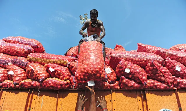 Indian labourers unload sacks of onion from a truck at a wholesale market in Chennai on June 1, 2016. India's economy grew 7.6 percent in 2015-16, official figures showed May 31, retaining its place as the world's fastest-growing major economy and providing a boost to the right-wing government as it marks two years in power. Gross domestic product (GDP) expanded at a faster pace in the fourth quarter of the financial year, growing 7.9 percent year-on-year, the Central Statistics Office data showed. (Photo by Arun Sankar/AFP Photo)