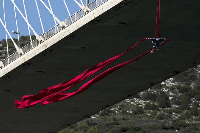 Extreme Aerial dance artist Katerina Soldatou performs on a 34 meters (111 foot) high bridge at the city of Chalkida about 80 kilometers (50 miles) north of Athens on Tuesday, June 13, 2017. Soldatou's performance is titled “Greece has soul” aiming to create environmental awareness and showcase Greek history. (pHOTO BY Petros Giannakouris/AP Photo)