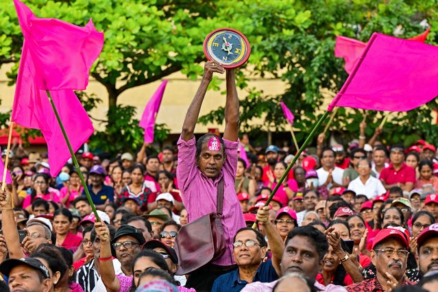 A supporter (C) of National People's Power (NPP) presidential candidate Anura Kumara Dissanayaka, holds the party symbol during a rally ahead of the upcoming presidential elections in Colombo on September 18, 2024. Sri Lanka's presidential hopeful Anura Kumara Dissanayaka wants a peaceful revolution after his Marxist party failed to seize power in two uprisings that left more than 80,000 people dead. The cash-strapped nation will vote for its next president on September 21. (Photo by Ishara S. Kodikara/AFP Photo)