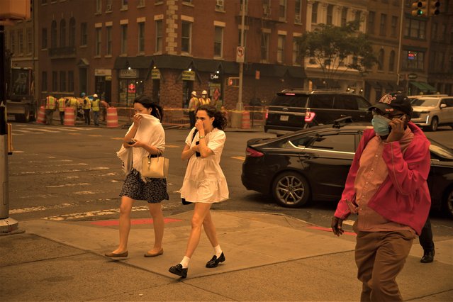 Pedestrians covering their faces walk on a street in New York, the United States on June 7, 2023. Smoke from raging wildfires in Canada has triggered air quality alerts in a number of U.S. states, with the sky over New York City quickly darkening Wednesday afternoon and New York State Governor Kathy Hochul calling the worsening air quality “an emergency crisis”. (Photo by Xinhua News Agency/Rex Features/Shutterstock)