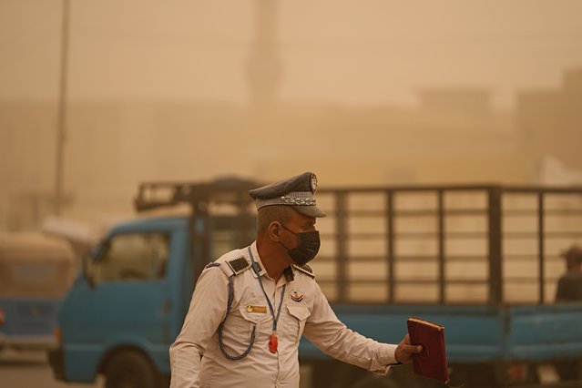 A policeman stands during a sandstorm in Baghdad, Iraq, Monday, May 23, 2022. (Photo by Hadi Mizban/AP Photo)