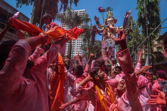 Indian devotees carry and worship an idol of the elephant-headed Hindu god Lord Ganesha for an immersion into the Arabian Sea as a part of the Ganesh Chaturthi festival, in Mumbai, India, 17 September 2024. The idol is meant for the festival Ganesha Chaturthi, a ten-day long event which is celebrated all over India. During the Ganpati festival, which is celebrated as the birthday of Lord Ganesh, idols of the Hindu deity are worshiped at hundreds of pandals or makeshift tents before they are immersed into water bodies. The Ganesh festival comes to an end on the day of Anant Chaturdashi. (Photo by Divyakant Solanki/EPA/EFE)