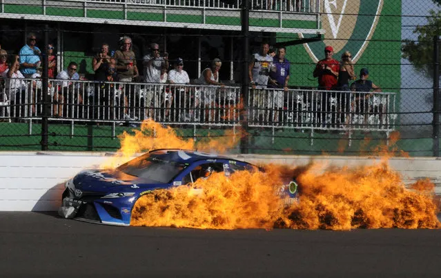 The car driven by Martin Truex Jr. burns after a crash with Kyle Busch during the NASCAR Brickyard 400 auto race at Indianapolis Motor Speedway in Indianapolis, Sunday, July 23, 2017. (Photo by Greg Huey/AP Photo)