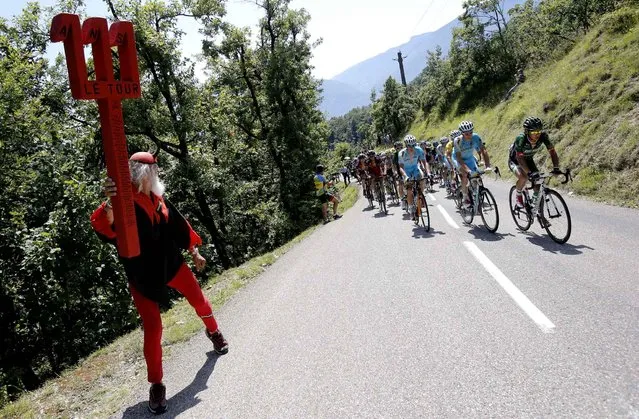 Dieter “Didi” Senft of Germany, known as El Diablo, left, encourages the pack led by Japan's Yukiya Arashiro, right, as it climbs Palaquit pass during the thirteenth stage of the Tour de France cycling race over 197.5 kilometers (122.7 miles) with start in Saint-Etienne and finish in Chamrousse, France, Friday, July 18, 2014. (Photo by Christophe Ena/AP Photo)