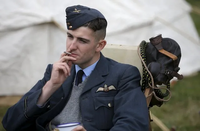 A “Battle of Britain” re-enactor smokes during a “Battle of Britain” commemoration event at Biggin Hill in southern England Britain, August 18, 2015. (Photo by Peter Nicholls/Reuters)