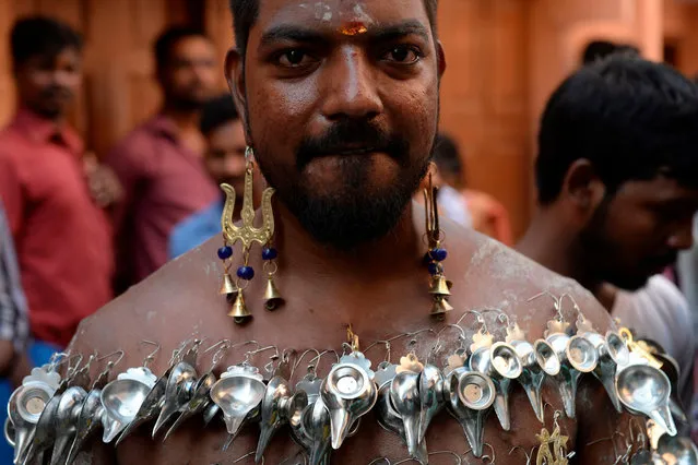 A Hindu devotee with his body pierced with paladai, a metal bowl with a spout mainly used to feed milk to infants, participates in a procession to mark “Shivratri” festival in Chennai on February 23, 2020. (Photo by Arun Sankar/AFP Photo)