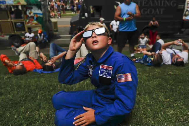 Tyler Hanson, of Fort Rucker, Ala., watches the sun moments before the total eclipse, Monday, August 21, 2017, in Nashville, Tenn. Millions of Americans gazed in wonder through telescopes, cameras and disposable protective glasses Monday as the moon blotted out the sun in the first full-blown solar eclipse to sweep the U.S. from coast to coast in nearly a century. (Photo by John Minchillo/AP Photo)
