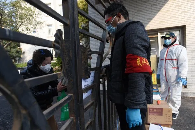 A resident scans a QR code with her mobile phone to pay for protective equipment purchased through group orders at a residential compound in Wuhan, Hubei province, China on February 21, 2020. (Photo by Reuters/China Stringer Network)