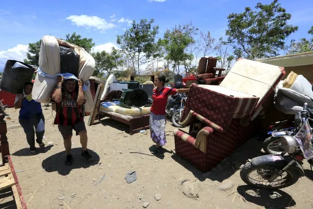 People carry their belongings after crossing the Tachira river border with Venezuela, in Villa del Rosario village, Colombia, August 25, 2015. (Photo by Jose Miguel Gomez/Reuters)