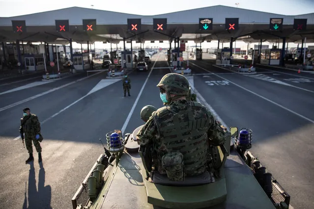 A Serbian army soldier sits on top of armoured personal carrier at the Serbia's Batrovci border crossing with Croatia's Bajakovo, as the number of coronavirus (COVID-19) cases grow around the world near Batrovci, Serbia, March 18, 2020. Under the new set of restrictions, the Serbian military will take over all border crossings and maintain guard at over a dozen state-operated camps for illegal migrants from Asia and the Middle East. (Photo by Marko Djurica/Reuters)