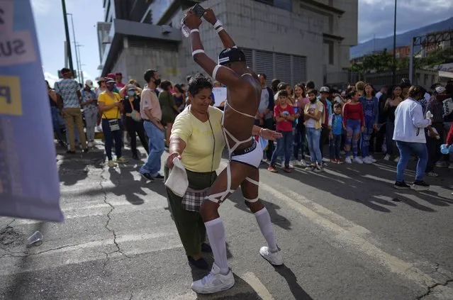 A woman and a participant dance on street during the Gay Pride parade in Caracas, Venezuela, Sunday, July 3, 2022. (Photo by Ariana Cubillos/AP Photo)