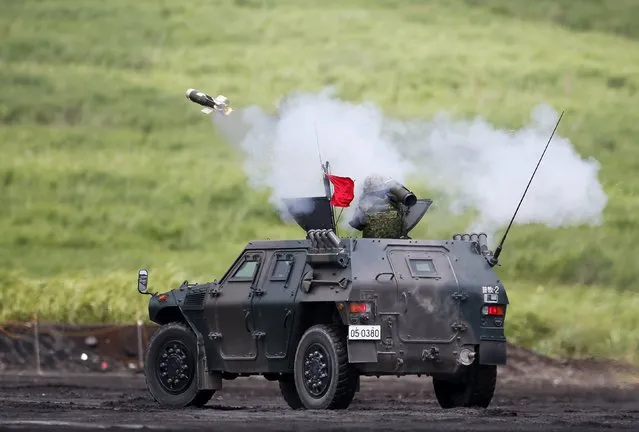 A Japanese Ground Self-Defense Force soldier on an armoured vehicle fires a guided anti-tank missile during an annual training session near Mount Fuji at Higashifuji training field in Gotemba, west of Tokyo, August 19, 2014. (Photo by Yuya Shino/Reuters)