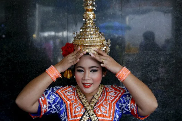 A classical dancer adjusts her costume before a performance at Erawan Shrine, the site of the recent bomb blast, in Bangkok August 30, 2015. Police hunting for the perpetrators of Thailand's deadliest bombing arrested a foreign man on Saturday they said fitted the description of a suspect seen leaving a rucksack at the site of the Bangkok blast nearly two weeks ago. (Photo by Jorge Silva/Reuters)