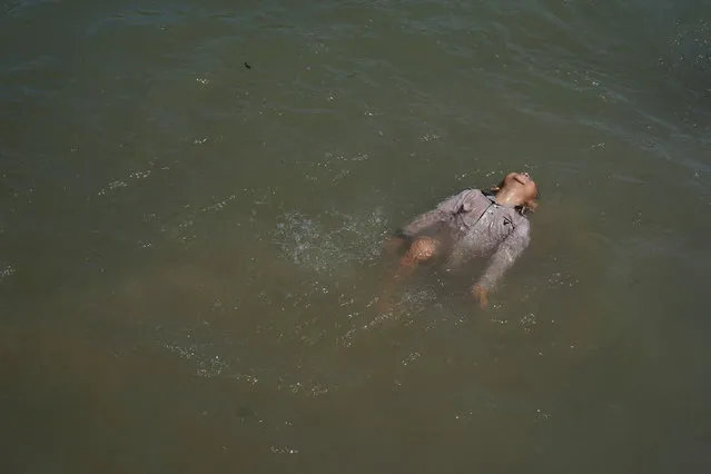 A migrant child, who is seeking asylum in the U.S., plays in Rio Grande river at an encampment of more than 2,000 migrants, as local authorities prepare to respond to the coronavirus disease (COVID-19) outbreak, in Matamoros, Mexico on March 23, 2020. (Photo by Go Nakamura/Reuters)