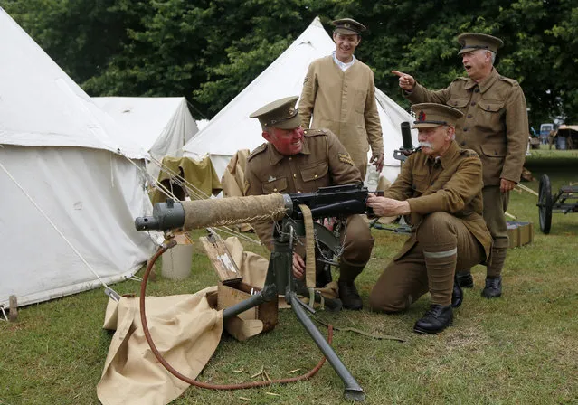 Police Community Support Officer (PCSO) Peter Austridge (L), portraying a Corporal in the 4th Battalion Royal Fusilier Territorial Army, recreates the camp life of a First World War soldier with other re-enactors Steve Neville (2nd L) Andrew Morgan (2nd R) and Phil Curtis (R) at the Colchester Military Tournament in Colchester, eastern England July 6, 2014. (Photo by Luke MacGregor/Reuters)