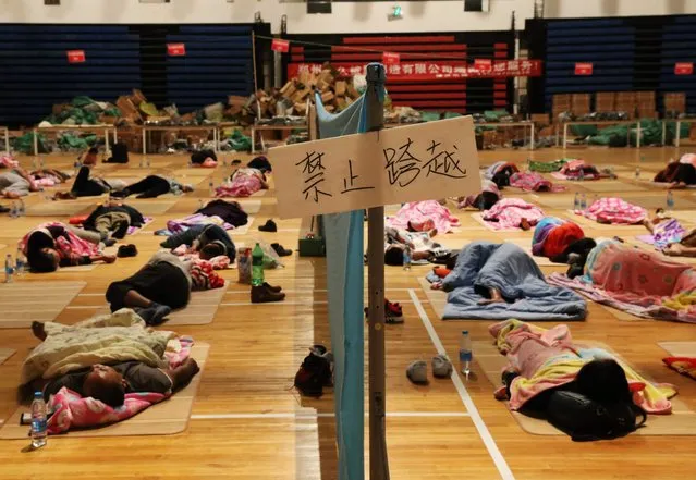 This photo taken on September 2, 2017 shows a sign forbidding crossing the rest area between men and women in a gymnasium at Zhengzhou University in Zhengzhou in China's central Henan province. Some 200 mats, drinking water and mobile phone chargers were provided by the university to parents who accompanied their children to school for registration at the facility for the start of the school year. (Photo by AFP Photo/Stringer)