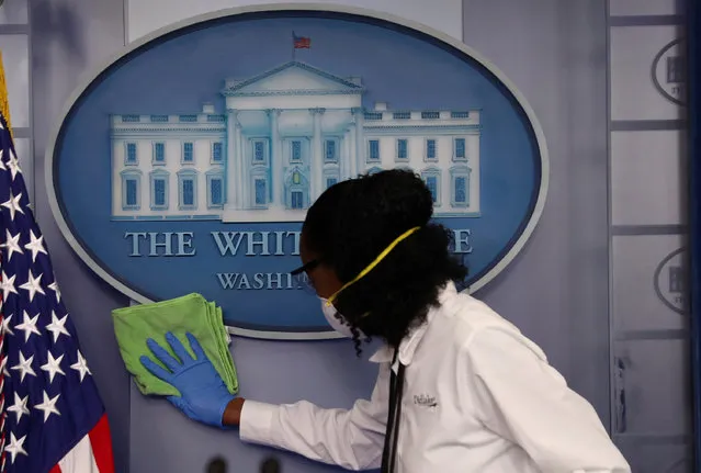 Workers clean the area around the podium before the daily coronavirus disease (COVID-19) outbreak task force briefing in the briefing room at the White House in Washington, U.S., April 13, 2020. (Photo by Leah Millis/Reuters)