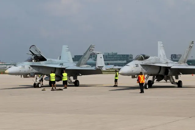 A CF-188 Hornet from 3 Wing Bagotville, Quebec sits next to an F/A 18C (VFA - 106) from Naval Air Station, Oceana in Virginia on the tarmac during media day for the Canadian International Air Show at Pearson Airport in Toronto, Ontario, September 3, 2015. (Photo by Louis Nastro/Reuters)