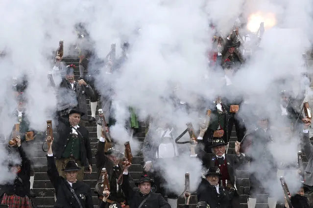 Bavarian riflemen and women in traditional costumes fire their muzzle loaders in front of the “Bavaria” statue on the last day of the 184th Oktoberfest beer festival in Munich, Germany, Tuesday, October 3, 2017. (Photo by Matthias Schrader/AP Photo)