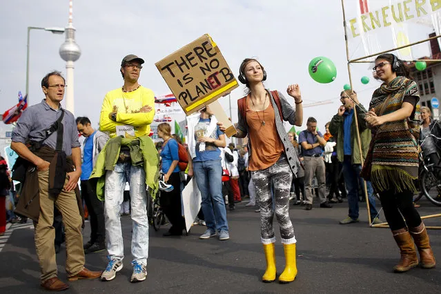 People hold banners and dance during a Climate Change March demanding politicians take tougher action to protect the climate in Berlin, September 21, 2014. (Photo by Thomas Peter/Reuters)