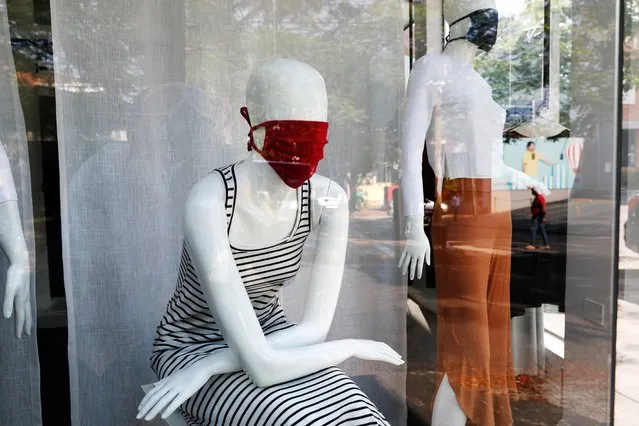 Mannequins wear masks, a reference to the new coronavirus, inside a newly opened clothing store in Asuncion, Paraguay, Monday, May 4, 2020. The government authorized the opening of some stores under the plan coined “Intelligent quarantine”. (Photo by Jorge Saenz/AP Photo)