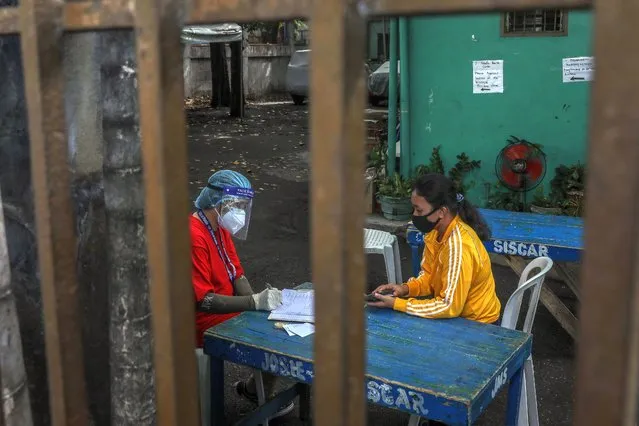 A woman is interviewed before undergoing a rapid test at a rapid testing facility amid the coronavirus pandemic in Manila, Philippines, 24 May 2020. People returning to work or to their provinces are required to have a certificate of clearance for COVID-19 as the lockdown gradually eases in Metro Manila. (Photo by Mark R. Cristino/EPA/EFE/Rex Features/Shutterstock)