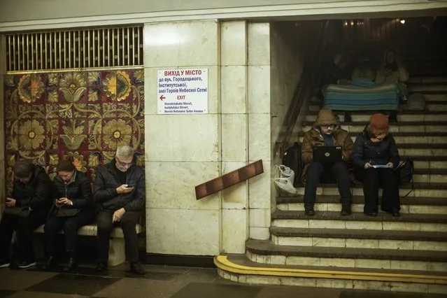 People sit in the subway, using it as a bomb shelter during an air raid alarm, in Kyiv, Ukraine, Thursday, October 20, 2022. (Photo by Francisco Seco/AP Photo)