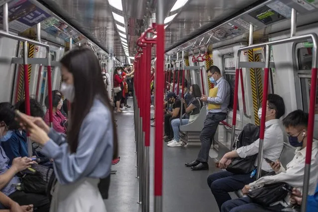 Commuters ride an MTR subway train in Hong Kong, Wednesday, October 19, 2022. Hong Kong's leader on Wednesday unveiled a new visa scheme to woo global talent, as the city seeks to stem a brain drain that has risked its status as an international financial center. (Photo by Vernon Yuen/AP Photo)