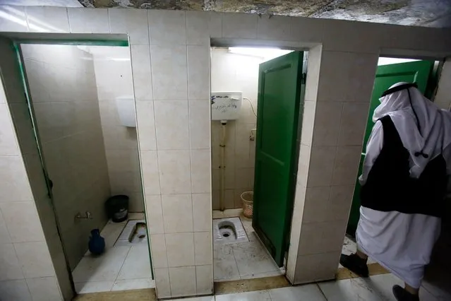 A Palestinian man walks into a cubicle at a public toilets in the city centre of the West Bank town of Hebron on November 14, 2017. (Photo by Hazem Bader/AFP Photo)