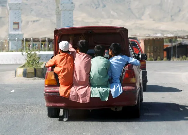 Afghan boys travel in the back of a car during Eid al-Fitr, a Muslim festival marking the end the holy fasting month of Ramadan, amid the spread of the coronavirus disease (COVID-19), in Laghman province, Afghanistan on May 24, 2020. (Photo by Parwiz via Reuters)