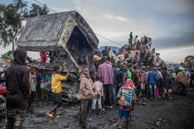 Residents dismantle a vehicle belonging to the United Nations Organization Stabilization Mission in the Democratic Republic of the Congo (MONUSCO) in Kanyaruchinya,  part of Nyiragongo territory in the Democratic Republic of Congo, on November 2, 2022, after it was set on fire overnight by angry residents. (Photo by Aubin Mukoni/AFP Photo)