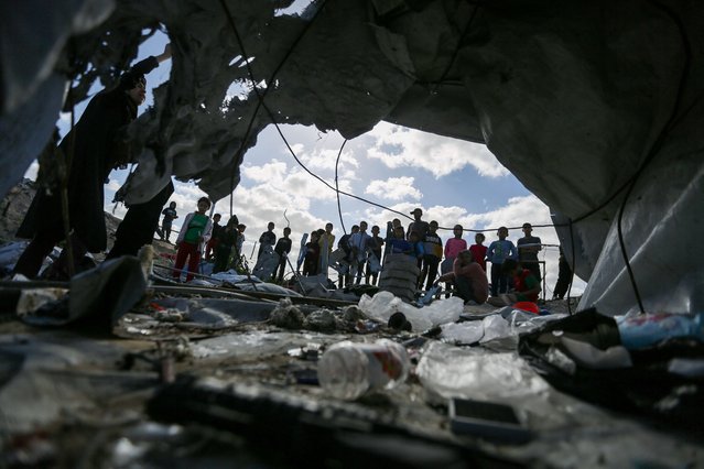 Palestinian children gather at the site of an Israeli strike on a tent housing displaced people, in Khan Younis, in the southern Gaza Strip, on March 19, 2025. (Photo by Hatem Khaled/Reuters)