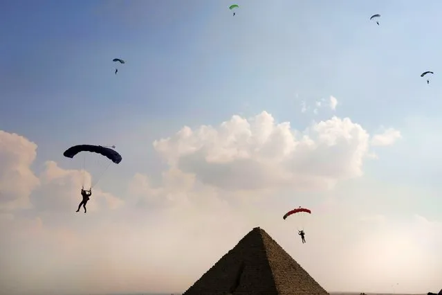 Parachutists approach the historical site of the Giza Pyramids, near Cairo, Egypt, Wednesday, November 2, 2022. More than 100 parachutists from 16 countries are participating at “Jump Like a Pharaoh” festival at the site of Giza Pyramids ahead of COP27 to be held in Egypt in November 6. (Photo by Amr Nabil/AP Photo)