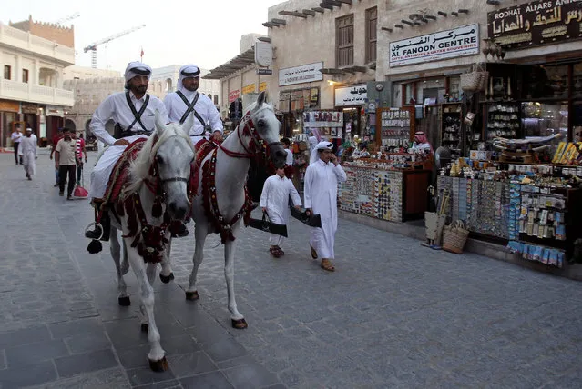 Qatari men ride horses as they parade at Souq Waqif market in Doha, Qatar August 30, 2016. (Photo by Naseem Zeitoon/Reuters)