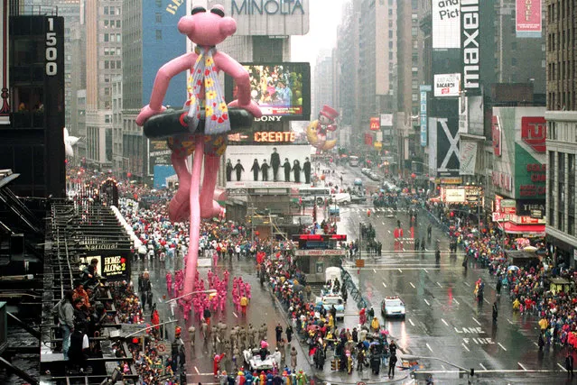 Spectators brave the elements as floats and balloons make their way through New York's Times Square during the Macy's Thanksgiving Day Parade along Broadway, Thursday, November 27, 1992. (Photo by Richard Harbus/AP Photo)