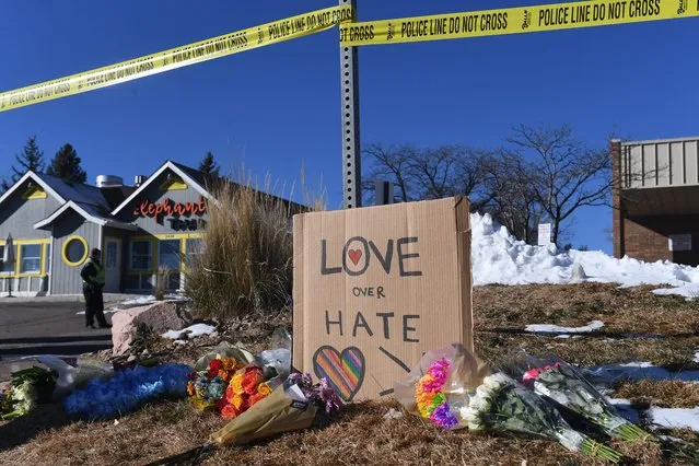 Bouquets of flowers and a sign reading “Love Over Hate” are left near Club Q, an LGBTQ nightclub in Colorado Springs, Colorado, on November 20, 2022. At least five people were killed and 18 wounded in a mass shooting at an LGBTQ nightclub in the US city of Colorado Springs, police said on November 20, 2022. (Photo by Jason Connolly/AFP Photo)