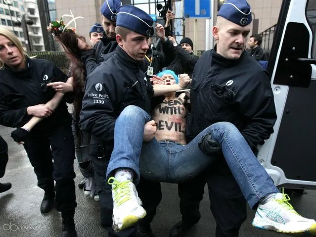 An activist of Ukraine's feminist movement Femen is taken away by the police as she demonstrates by the EU Council building where the EU-Russia summit is taking on December 21, 2012 in Brussels, Belgium. (Photo by Georges Gobet/AFP Photo)