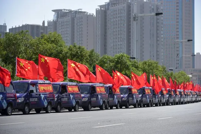 Vehicles carrying 66 Chinese national flags run along a street on China's National Day in Zhengzhou, Henan province, October 1, 2015. Thursday marks the 66th anniversary of the founding of the People's Republic of China. (Photo by Reuters/Stringer)