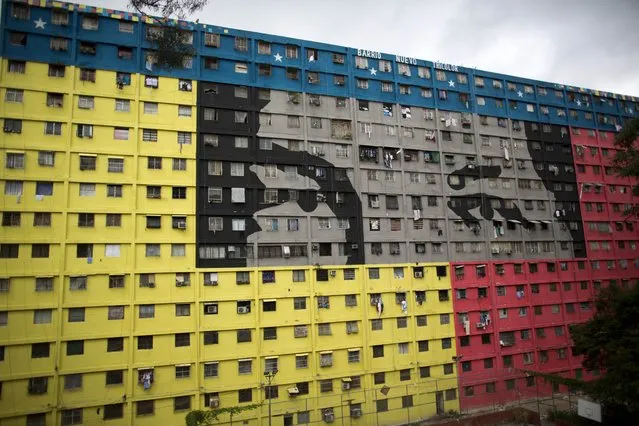 In this Sunday, December10, 2017 photo, an apartment building is covered with the eyes of Venezuela's late President Hugo Chavez during mayoral elections in the 23 de enero neighborhood of Caracas, Venezuela. After the ruling party captured a majority of mayoral seats across the country, President Nicolas Maduro said opposition parties would be banned from future elections as punishment for boycotting the races. (Photo by Ariana Cubillos/AP Photo)