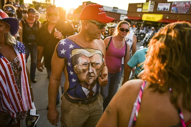 Johne Riley walks down Main Street showing off his chest painted with a portrait of President Donald Trump during the 80th Annual Sturgis Motorcycle Rally on August 7, 2020 in Sturgis, South Dakota. While the rally usually attracts around 500,000 people, officials estimate that more than 250,000 people may still show up to this year's festival despite the coronavirus pandemic. (Photo by Michael Ciaglo/Getty Images)