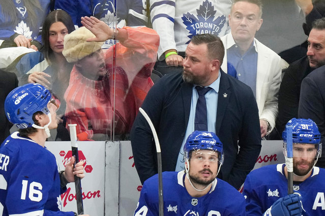 Justin Bieber, second left in the background, bangs on the glass as he sits behind the Toronto Maple Leafs bench during their loss to the Florida Panthers during the third period of an NHL Stanley Cup playoff hockey game in Toronto, Sunday, May 18, 2025. (Photo by Chris Young/The Canadian Press via AP Photo)